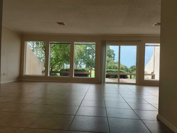 a view of an empty room window and a kitchen