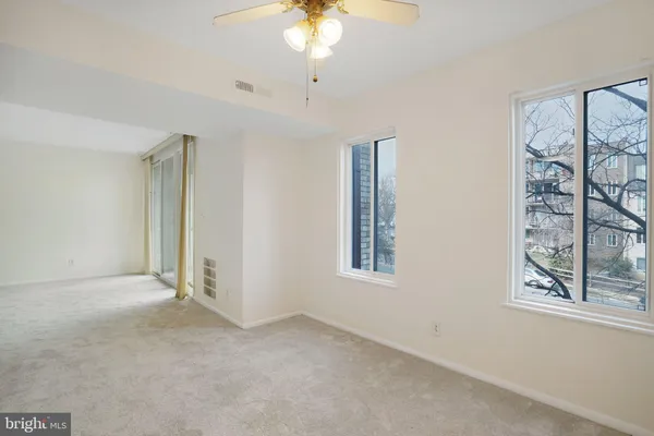 an empty room with windows and closet