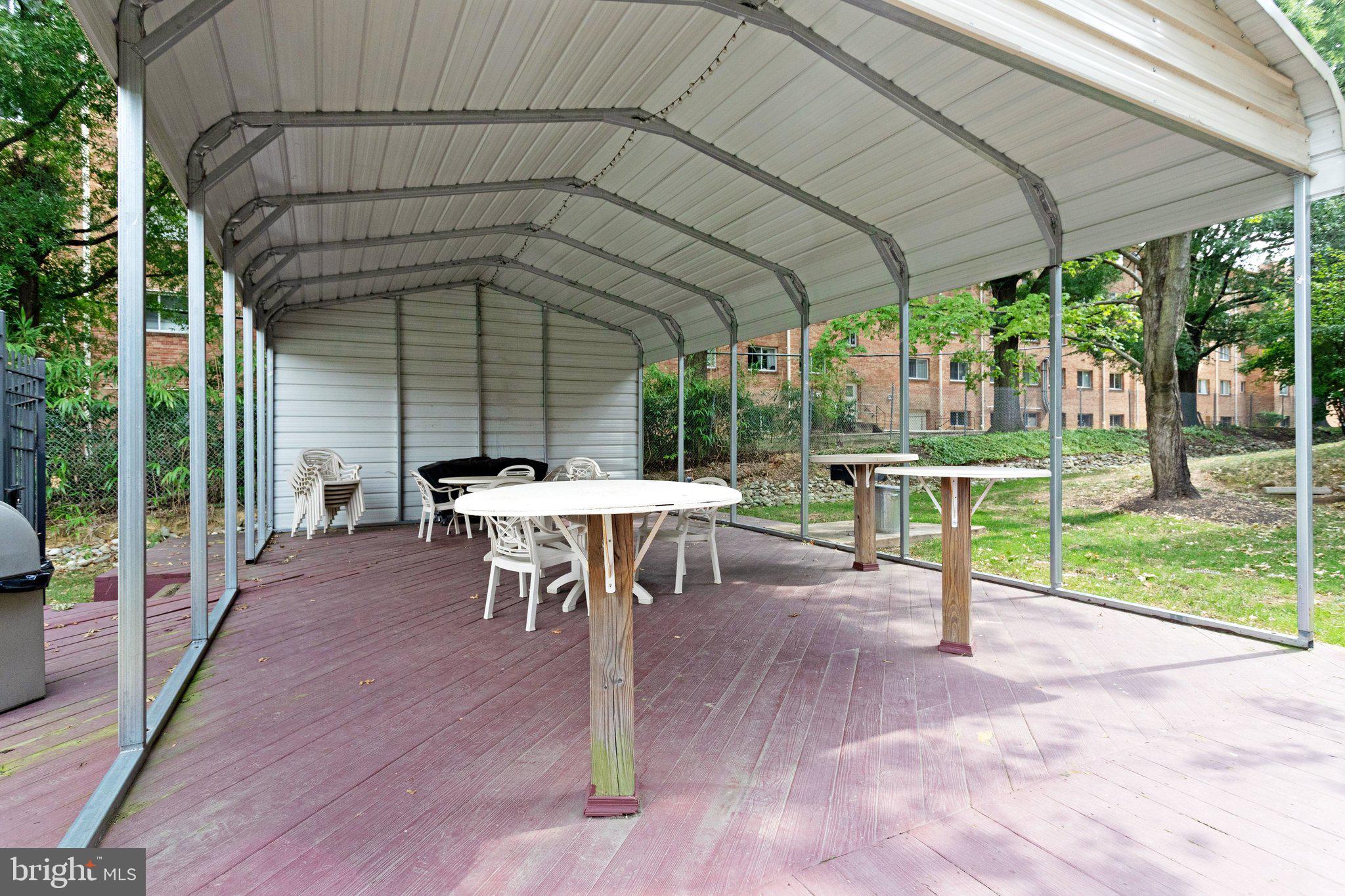 5020 7th Road South, Unit 102 Arlington, VA 22204 - Photo 29 of 30 a view of a patio with table and chairs under an umbrella with a small yard