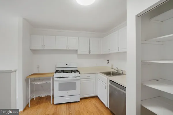 a kitchen with white cabinets and white appliances