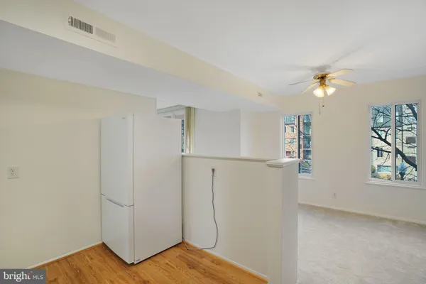 a view of a room with wooden floor and a ceiling fan