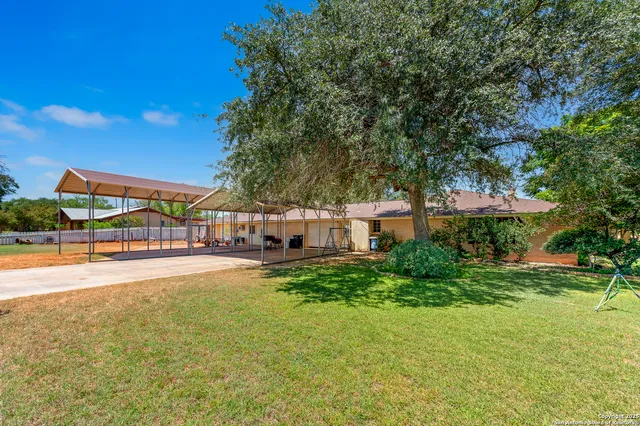 a view of a house with pool and a yard