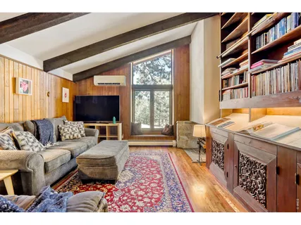 a living room with furniture a rug and a floor to ceiling window