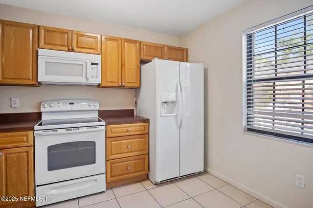 a kitchen with a stove top oven cabinets and a refrigerator