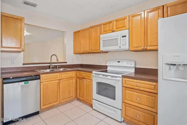 a kitchen with granite countertop cabinets stainless steel appliances and a sink
