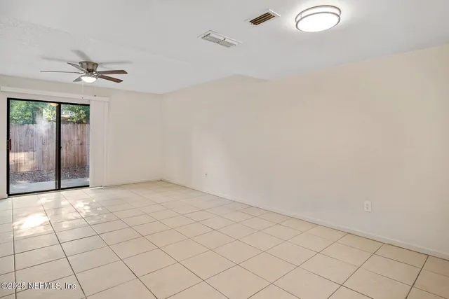 an empty room with windows and fan