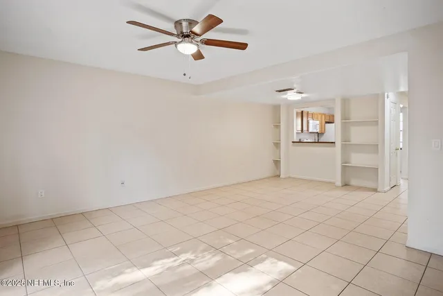 an empty room with fan and windows