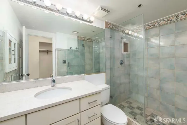 a bathroom with a sink toilet a mirror and shower