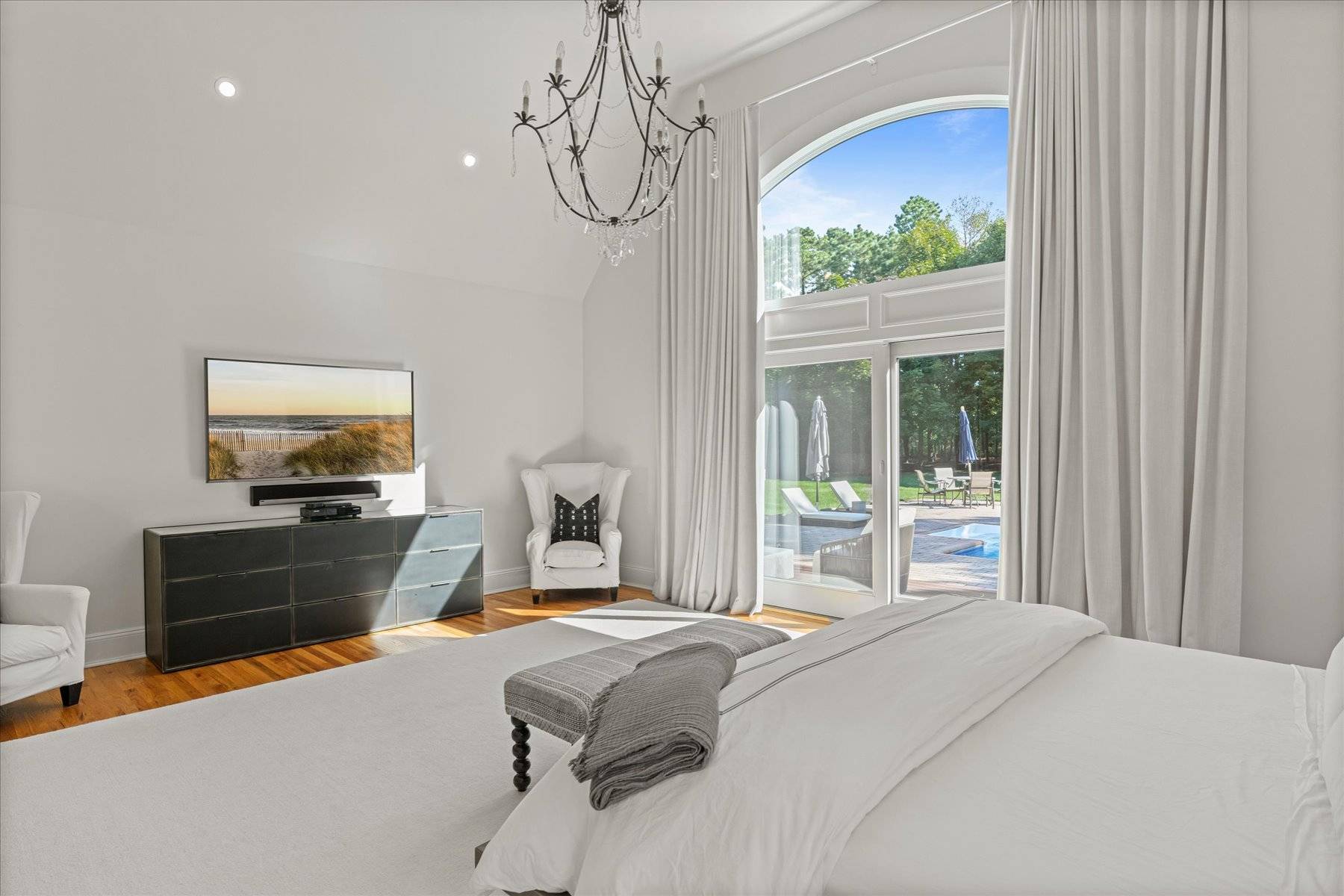 33 Post Fields Lane Quogue, NY 11959 - Photo 9 of 30 a bedroom with a bed and a chandelier
