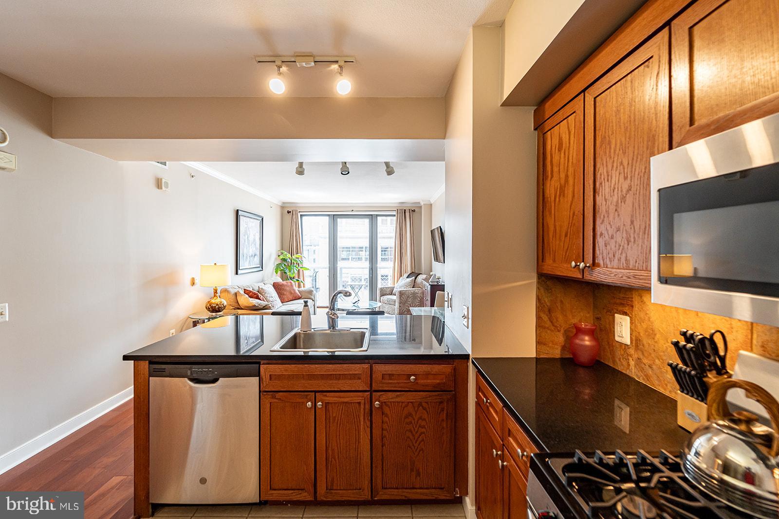 631 D Street Northwest, Unit 1231 Washington, DC 20004 - Photo 11 of 48 a kitchen with stainless steel appliances a sink stove and cabinets