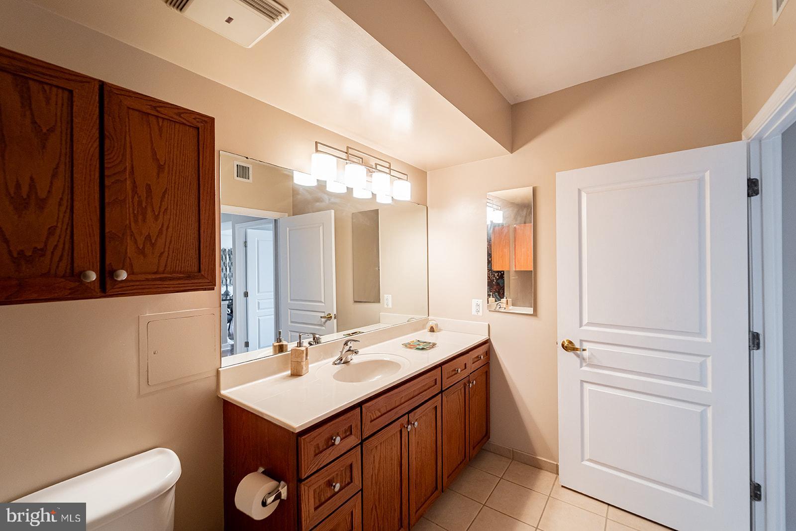 631 D Street Northwest, Unit 1231 Washington, DC 20004 - Photo 13 of 48 a bathroom with a sink a toilet and a mirror