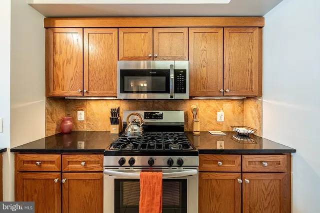 a kitchen with stainless steel appliances granite countertop a refrigerator and a sink