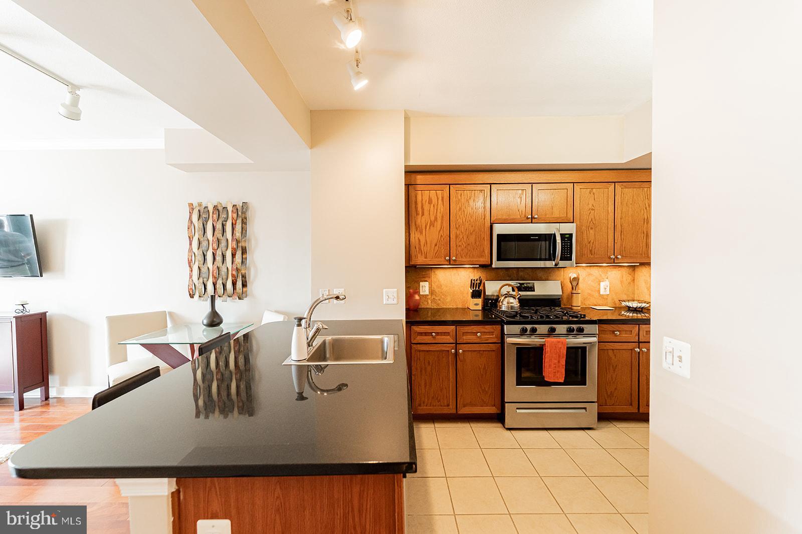 631 D Street Northwest, Unit 1231 Washington, DC 20004 - Photo 8 of 34 a kitchen with stainless steel appliances granite countertop a stove a sink and a microwave