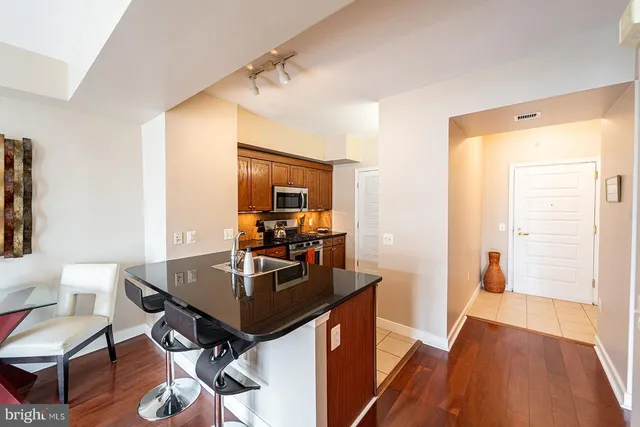 a kitchen with stainless steel appliances granite countertop a stove a sink and a microwave