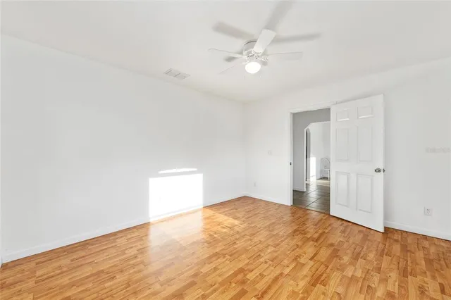a bedroom with a large bed and a chandelier fan