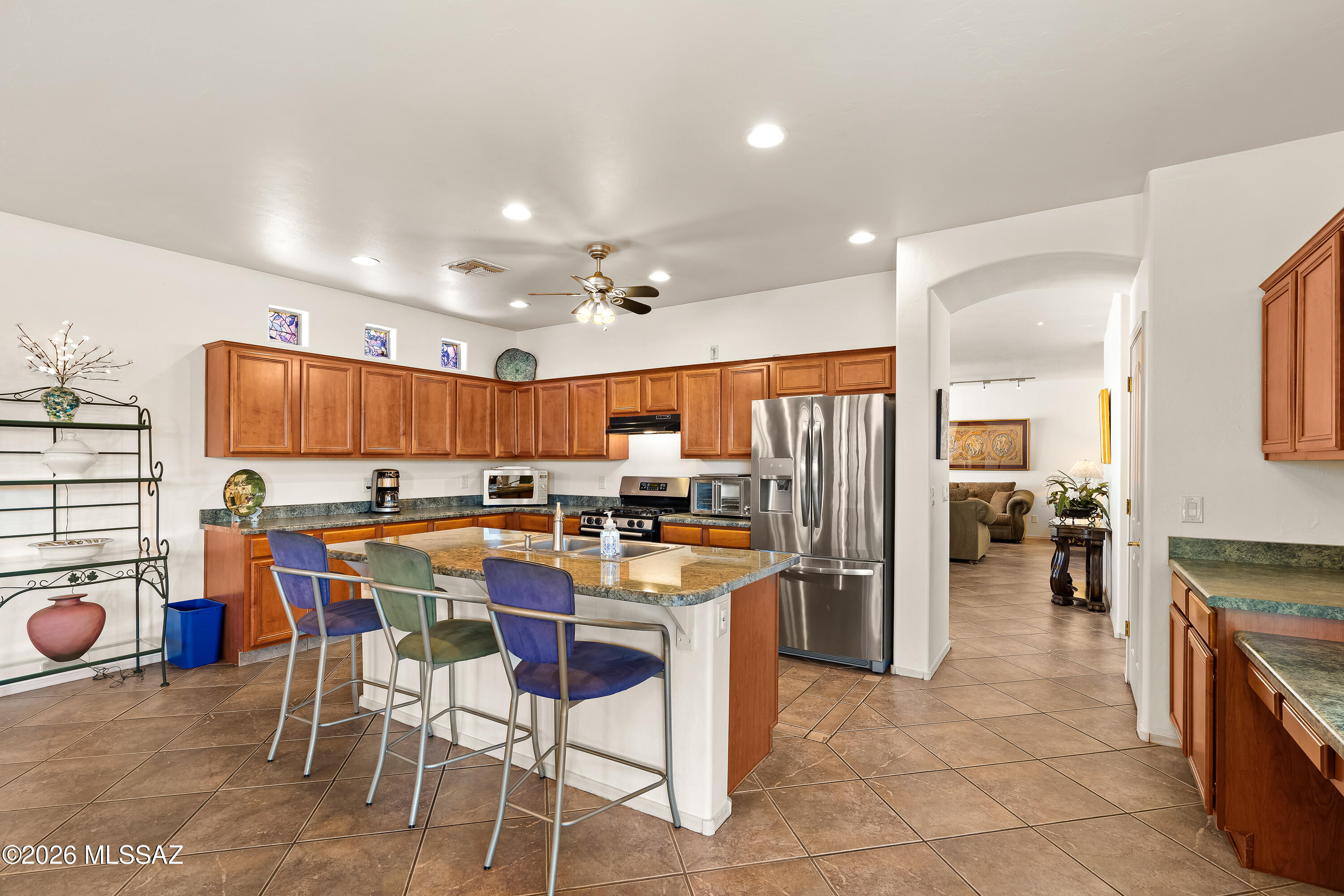 3396 North Camino Rio Colorado Tucson, AZ 85712 - Photo 8 of 32 a kitchen with stainless steel appliances kitchen island granite countertop a table chairs and a refrigerator