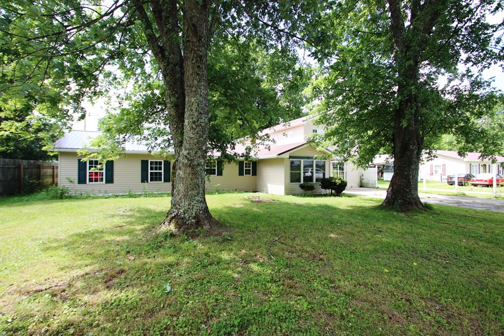 777 Lovejoy Road Sparta, TN 38583 - Photo 4 of 47 a yellow house in middle of the forest