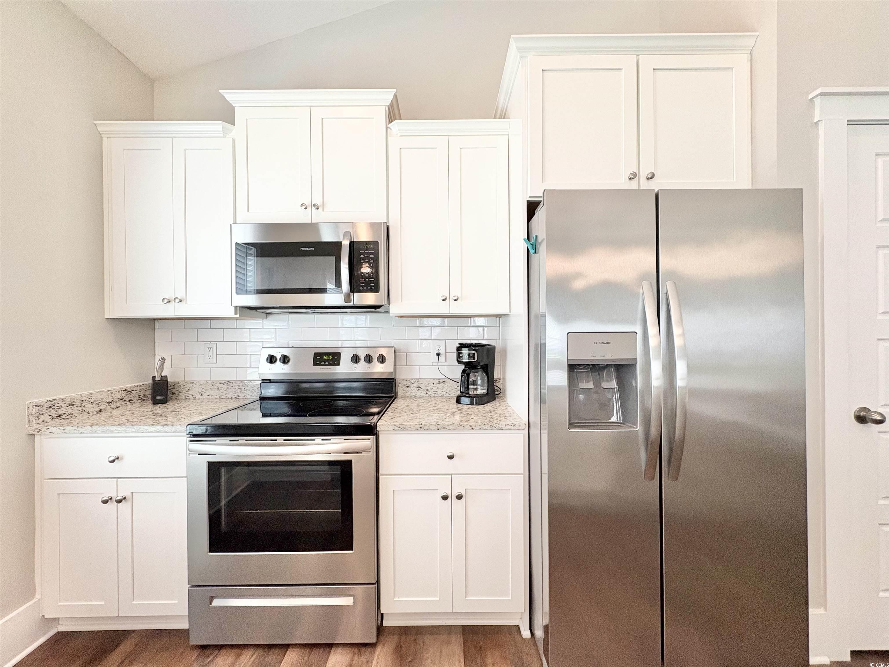 11124 Lee Circle Murrells Inlet, SC 29576 - Photo 4 of 25 Kitchen featuring backsplash, white cabinetry, lof