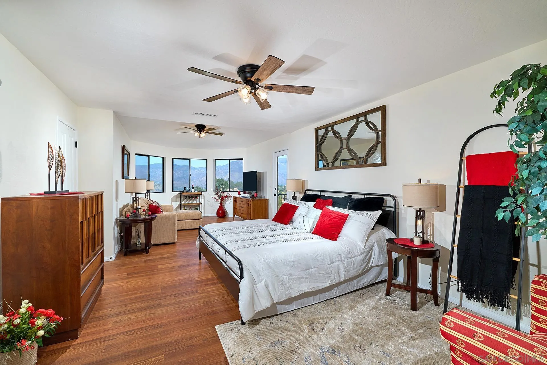 13588 McNally Road Valley Center, CA 92082 - Photo 22 of 43 a bedroom with a bed and a chandelier