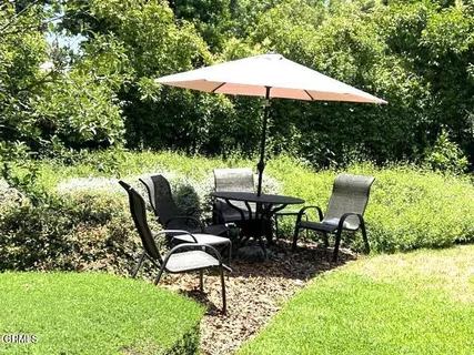 a backyard of a house with table and chairs