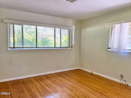 a view of a room with wooden floor and a window