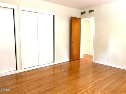 a view of an empty room with wooden floor