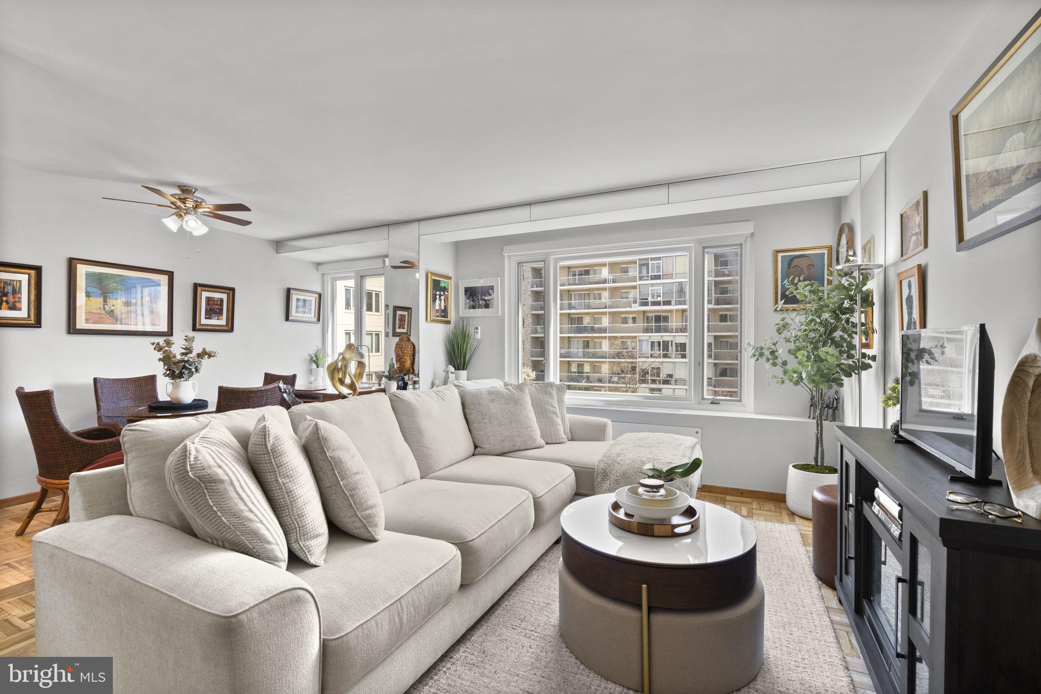 a living room with furniture a flat screen tv and a large window