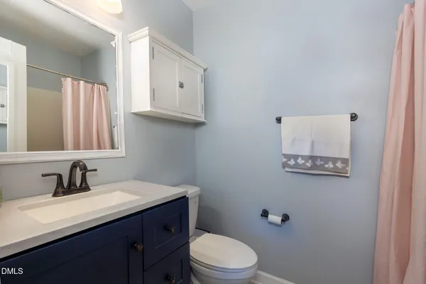 a bathroom with a toilet sink vanity and mirror