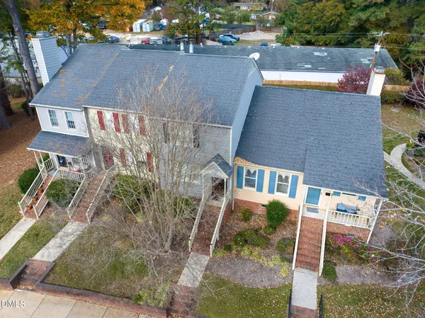 an aerial view of residential houses with outdoor space and parking