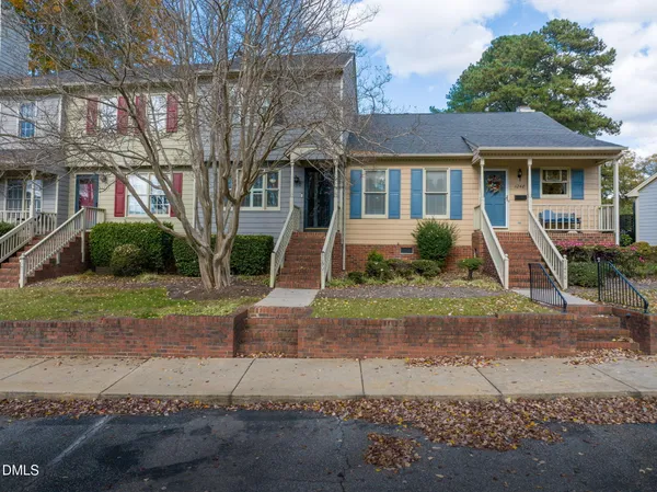 a front view of a house with a yard and potted plants