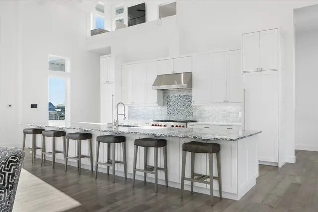 a large kitchen with kitchen island a large window