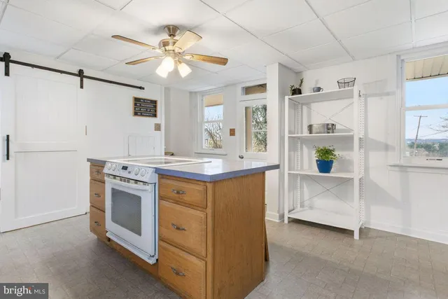 a kitchen with kitchen island white cabinets and stainless steel appliances