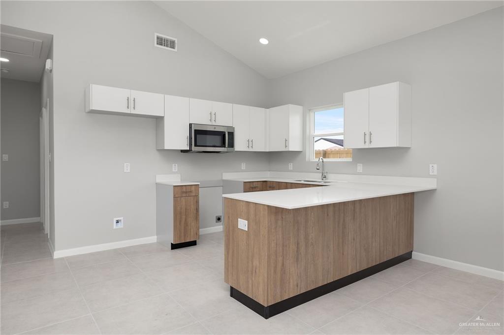 2701 Robin Road Weslaco, TX 78596 - Photo 18 of 30 a kitchen with stainless steel appliances a stove a sink a microwave a refrigerator and cabinets