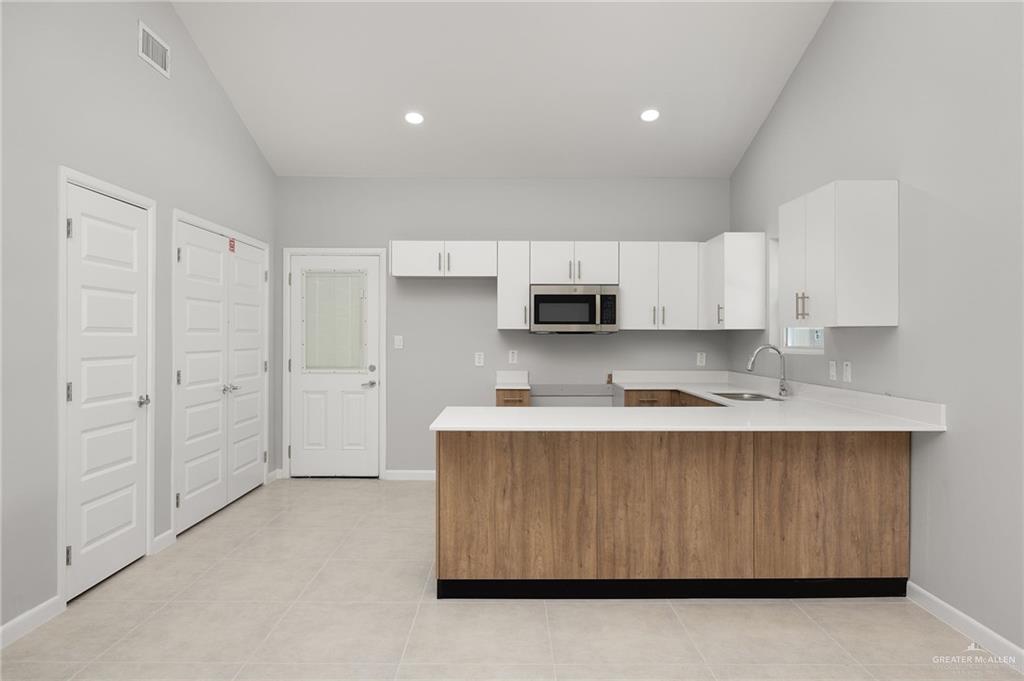 2701 Robin Road Weslaco, TX 78596 - Photo 6 of 30 a kitchen with stainless steel appliances granite countertop a stove a sink and a refrigerator with white cabinets