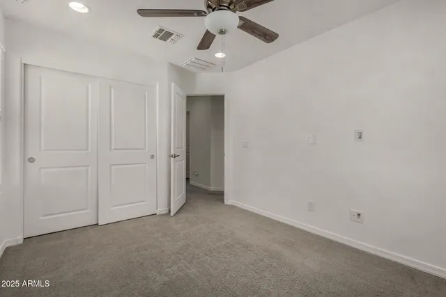 an empty room with a ceiling fan and a window