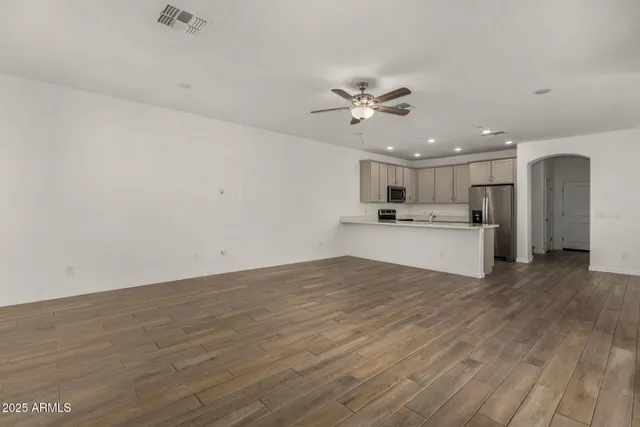 a view of a kitchen with a sink a ceiling fan and wooden floor