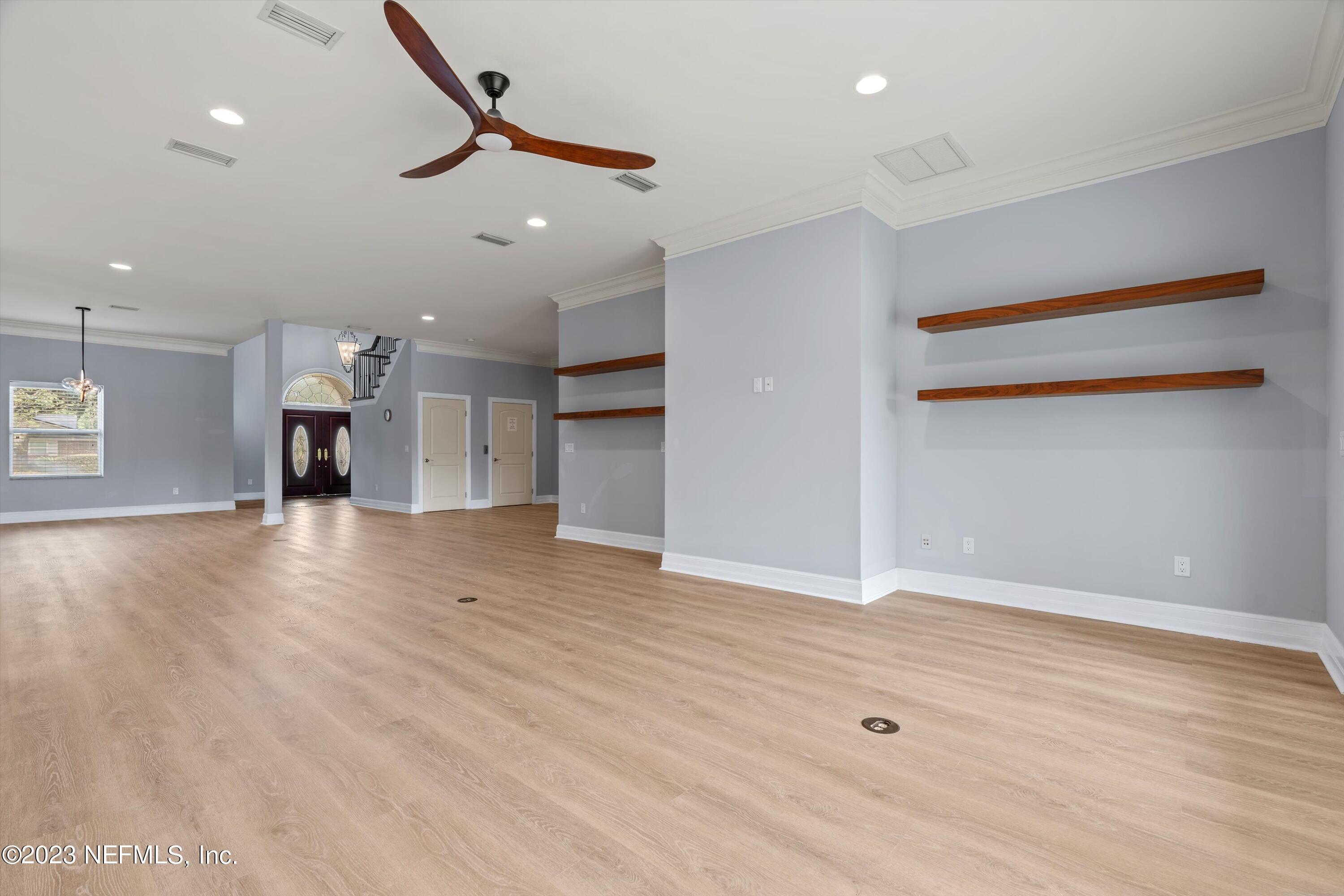 7936 Pine Lake Road Jacksonville, FL 32256 - Photo 15 of 52 an empty room with wooden floor a ceiling fan and windows