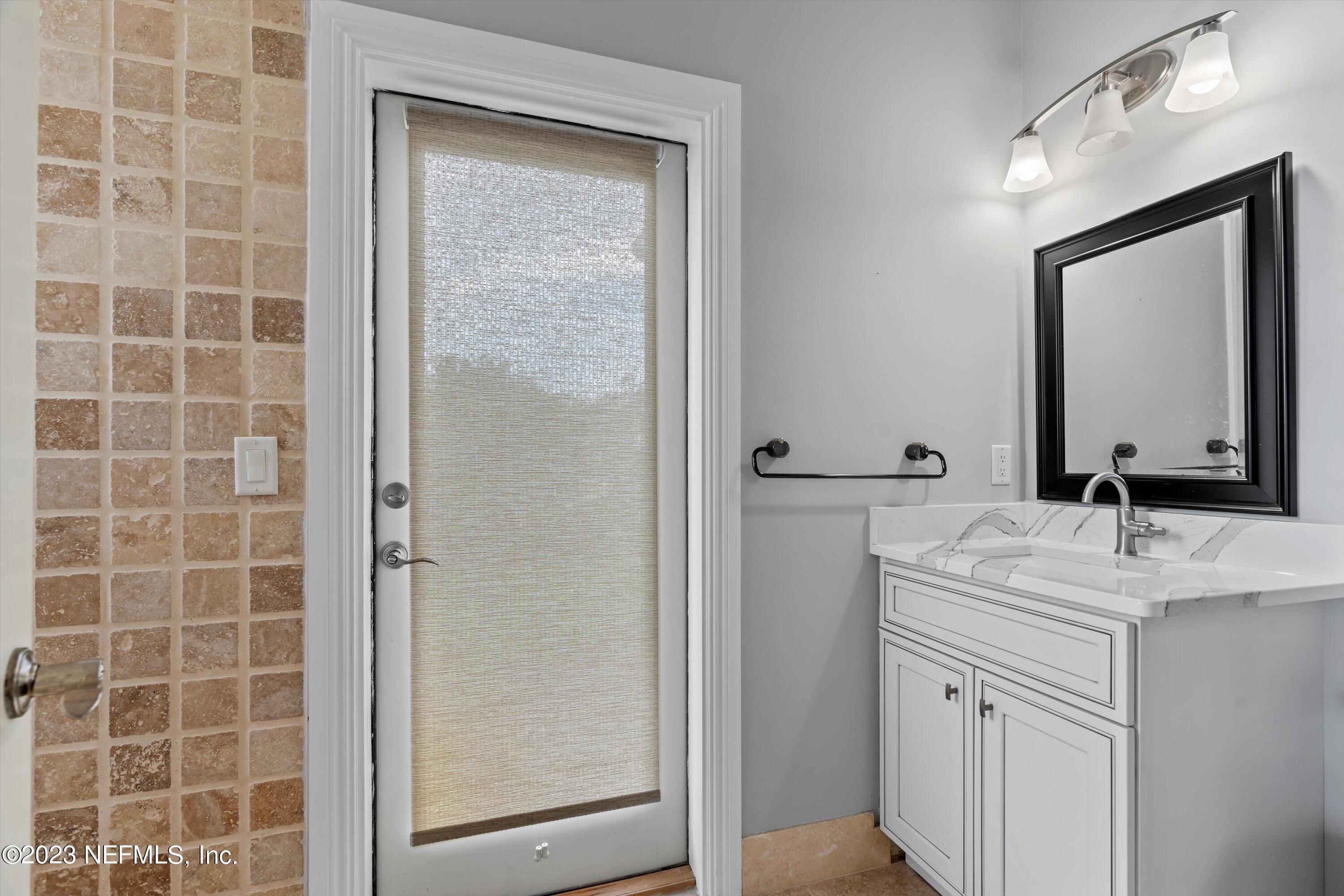 7936 Pine Lake Road Jacksonville, FL 32256 - Photo 24 of 52 a bathroom with a granite countertop sink a mirror and shower