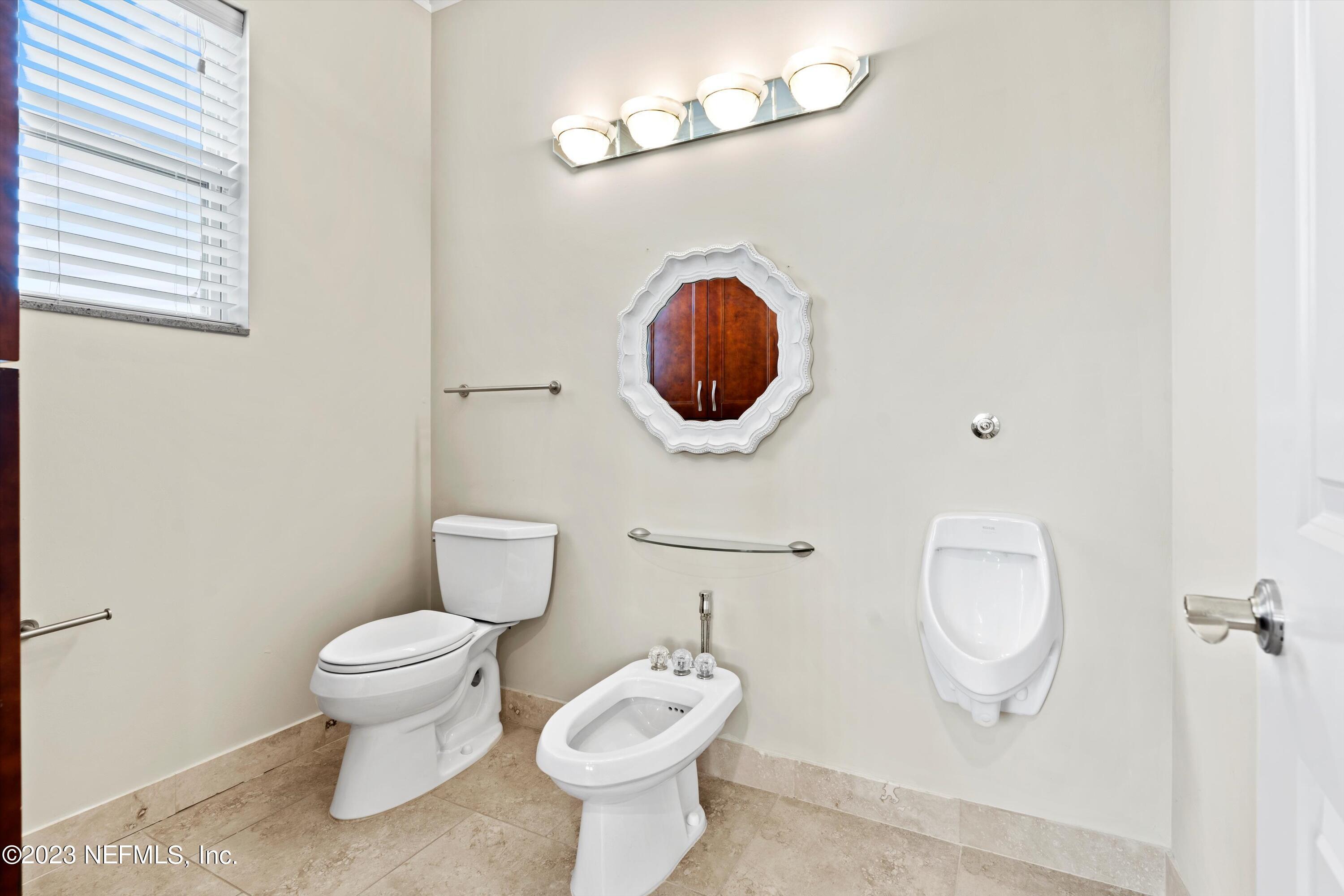 7936 Pine Lake Road Jacksonville, FL 32256 - Photo 48 of 52 a bathroom with a toilet a sink and mirror