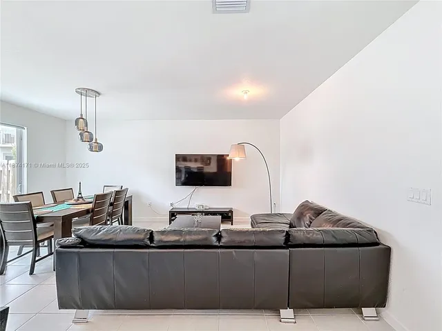 a living room with furniture a dining table and a chandelier