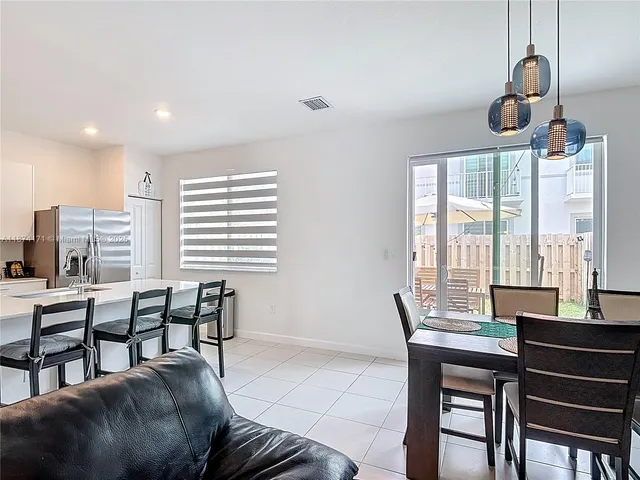 a living room with furniture kitchen view and a chandelier