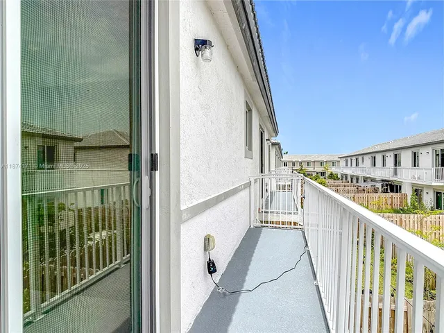 an aerial view of residential houses with outdoor space and ocean view