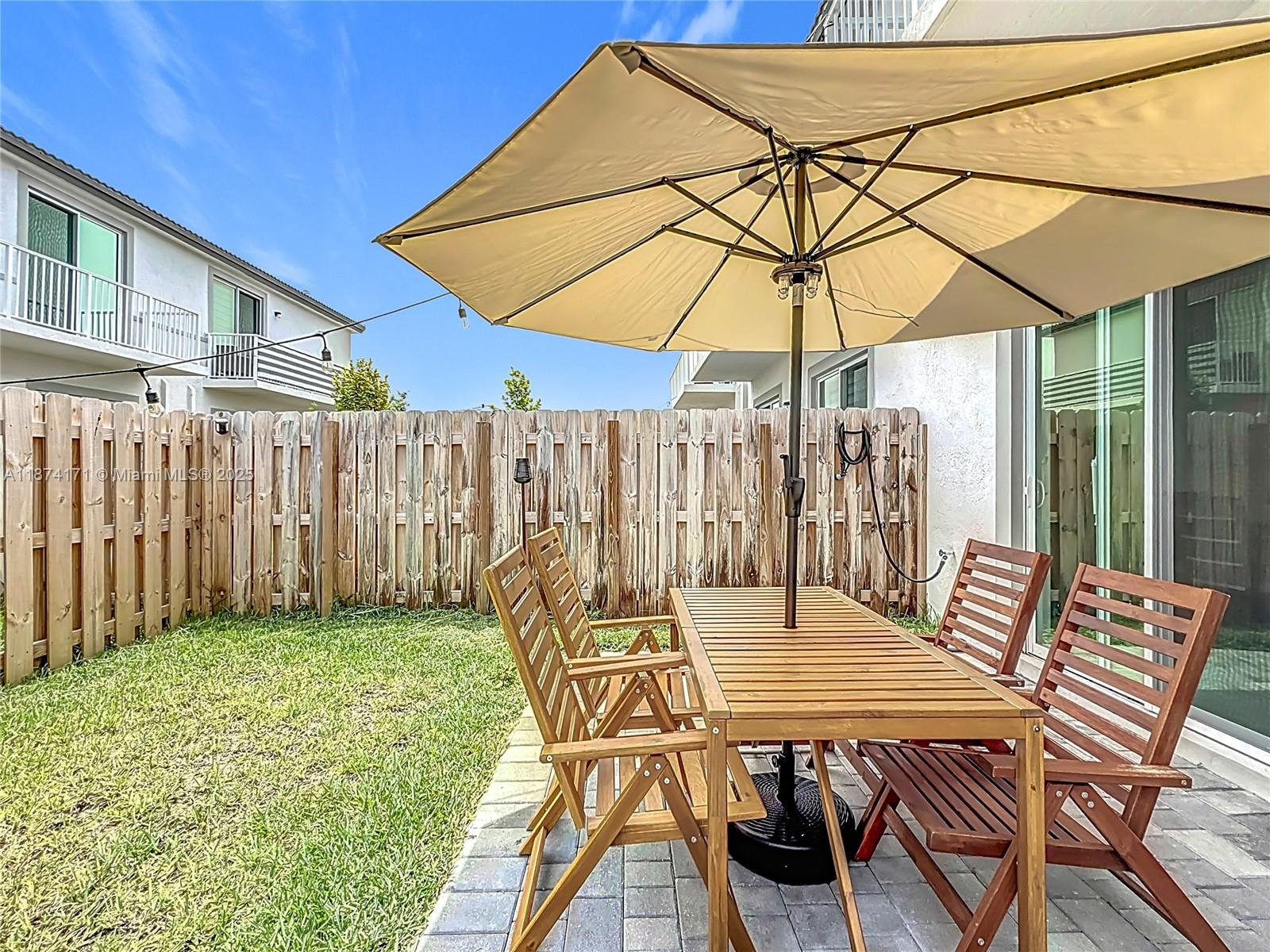 716 Southeast 14th Street Homestead, FL 33034 - Photo 51 of 60 a view of a patio with a table and chairs under an umbrella