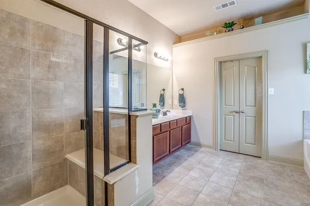 a bathroom with a tub sink vanity and mirror