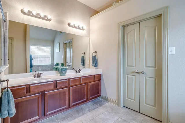 a bathroom with double vanity sinks and a mirror