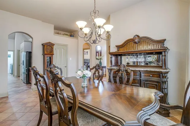 a dining room with chandelier and wooden floor