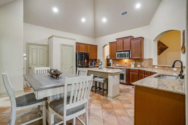 a kitchen with a sink a counter top space appliances and cabinets