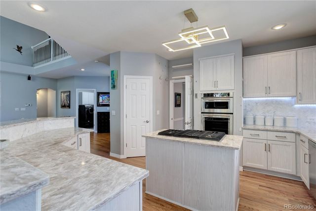 a kitchen with stainless steel appliances kitchen island granite countertop a sink stove and refrigerator