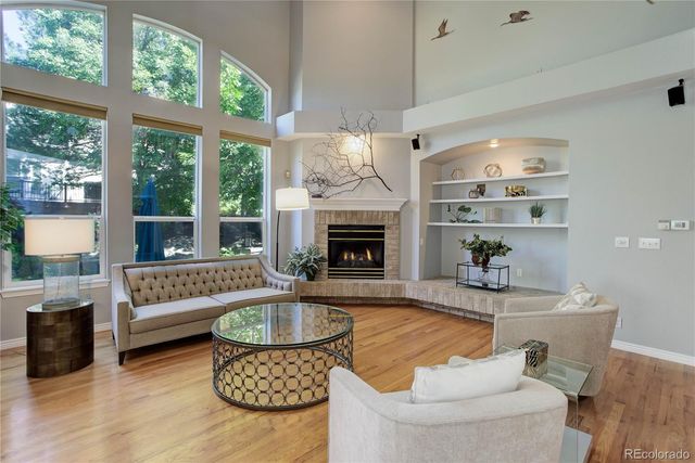 a living room with furniture a fireplace and a large window