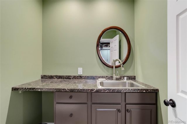 a bathroom with a granite countertop sink and a mirror